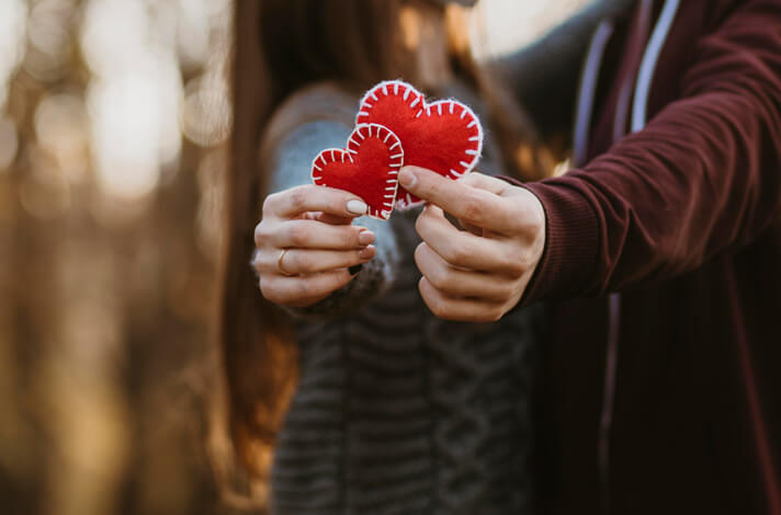 Ljubavni par drži dva srca u rukama